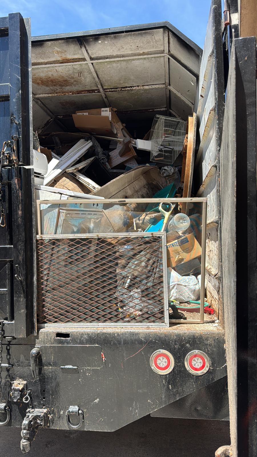 Truck bed loaded with construction debris and boxes