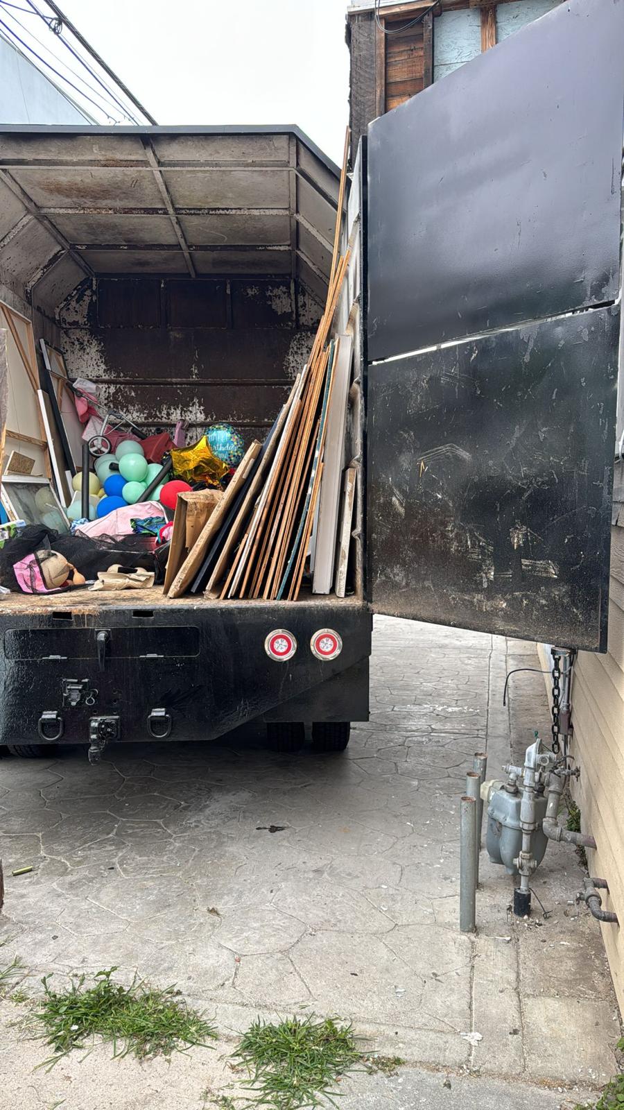 Truck loaded with wood planks and household items