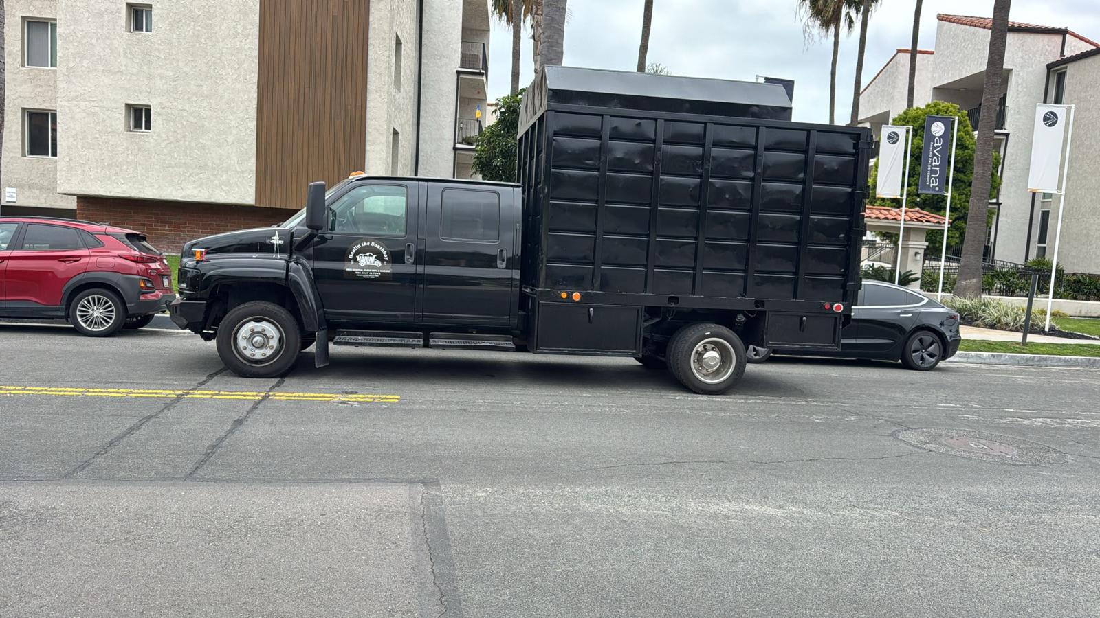 Pepe's Haulin black dump truck parked on street